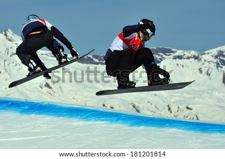 VEYSONNAZ, SWITZERLAND - MARCH 11: BANKES and RAMOIN take a jump together in the Snowboard Cross World Cup: March 11, 2014 in Veysonnaz, Switzerland