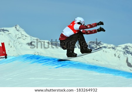 VEYSONNAZ, SWITZERLAND - MARCH 11: Kevin HILL (CAN) jumping in the Snowboard Cross World Cup: March 11, 2014 in Veysonnaz, Switzerland