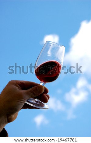 Red Wine held in the hand of the producer outside his wine cellar