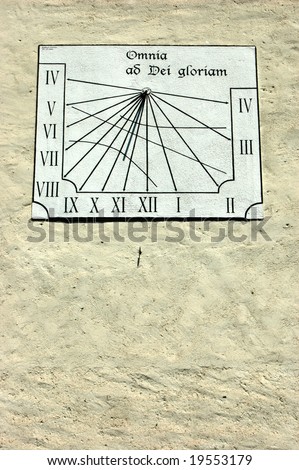 Sundial on a old swiss church showing nearly 11 O\'clock, whereas summertime is actually nearly midday.  Inscription reads \'Everything to the glory of God\'.