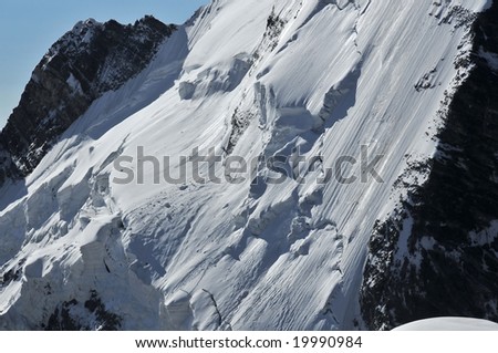 The notorious seracs which form a near impassable barrier to climbers on the north face of the Dent d\'Herens in the Swiss Alps.  On the right the regular avalanches have polished the ice.