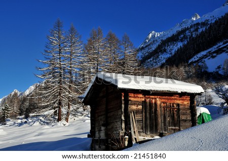 old log cabin in the swiss alps covered with fresh snow