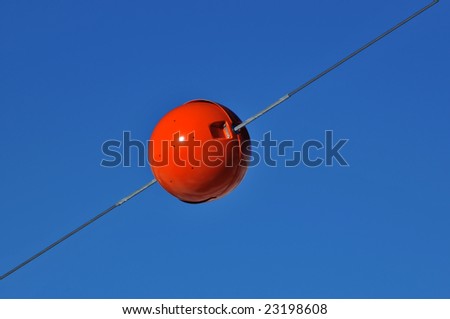a radar reflector on a cable painted red for maximum visibility to alert helicopters to the risk of hitting a cable in a ski resort