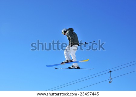Aeroski: a male skier in white pants on a high jump lookling very relaxed
