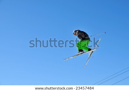 Aeroski: a skier in fluorescent green pants jumping high