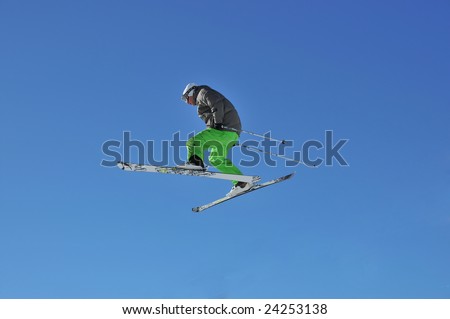 Aeroski: skier in bright green trousers jumping in high in the air