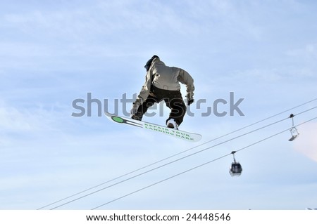 Girl on a snowboard high in the sky during a big jump