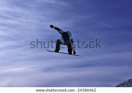 A snowboarder on a high jump clothed in blue and white, touches his board in mid-flight