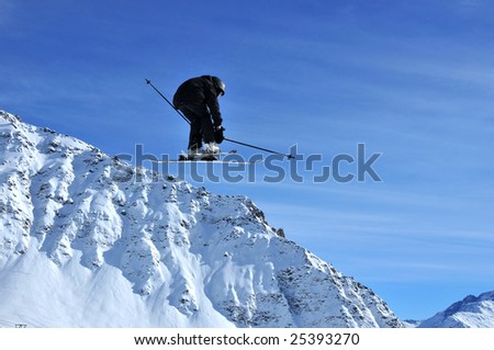 a ski jumper dressed in black performing a very high jump and adopting a crouched position