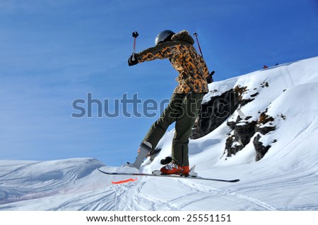 aeroski: a skier performing a tele-heli (crossed skis) during a jump