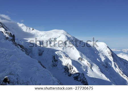 the dome du gouter, the ice dome just below the summit of Mt Blanc in France. To the right the aiguille du gouter