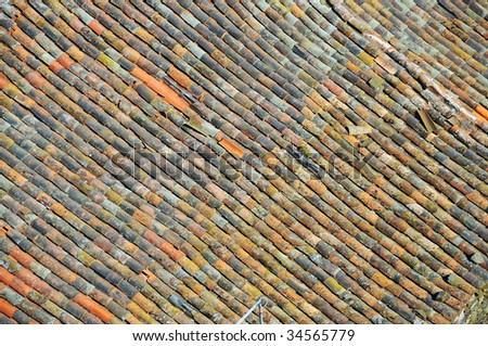 multi-colored clay tiles on an old roof, in need of repair
