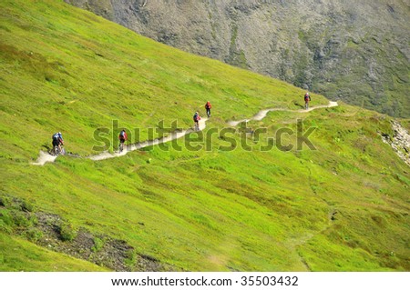 a group of mountain bikers on a path in the mountains on the tour de mont blanc
