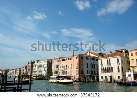 water taxis take tourists along the grand canal in Venice. Elegant venetian houses line the banks of the canal