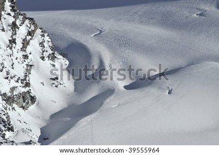 ski turns in powder snow on the rosablanche glacier in switzerland, made by helicopter skiers