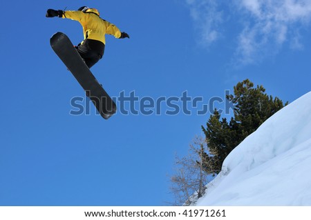 snowboarder jumping off a ridge of snow