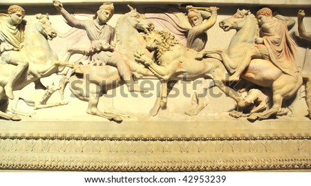 ancient greek sculpture in marble of persians and greeks hunting  a lion using dogs horses, an axe and a spear