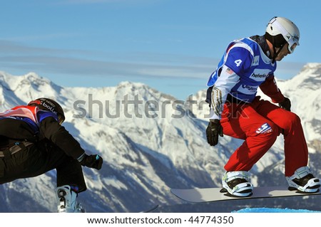 VEYSONNAZ, SWITZERLAND - JANUARY 15: World championship Snowboard cross  finals. Nick Baumgartner leads over the jump. January 15 in Veysonnaz, Switzerland.