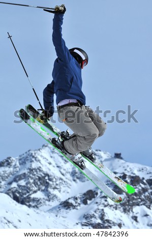 a freestyle skier touches his skis during a jump