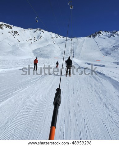 two ski lifts in parallel pull skiers to the top of the slope using the drag method