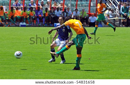 SION, SWITZERLAND - JUNE 4: Sanogo of Ivory Coast shoots in a friendly match against Japan for the 2010 world cup while Endo watches:  June 4, 2010 in Sion Switzerland
