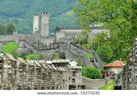 Extensive and well preserved medieval castle walls defending the southern swiss border with mountains in the background