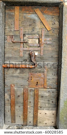 an old castle door covered in iron reinforcement plates and locks for  security