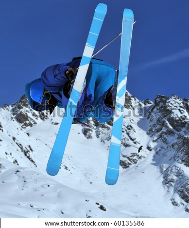 a ski freerider in blue performs a jump