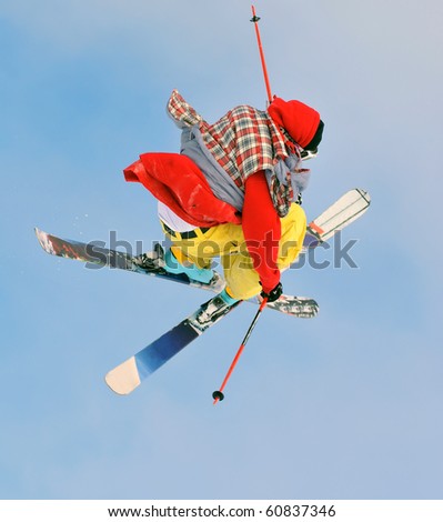freestyle skier in bright colours performs a high jump