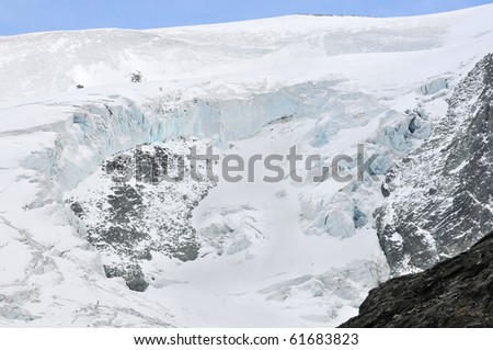 A large piece of glacier has weakened broken away from this mountain side leaving ice cliffs due to global warming