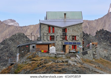 An isolated  mountain refuge in the european alps showing drinking water recovery,  and solar energy panels,