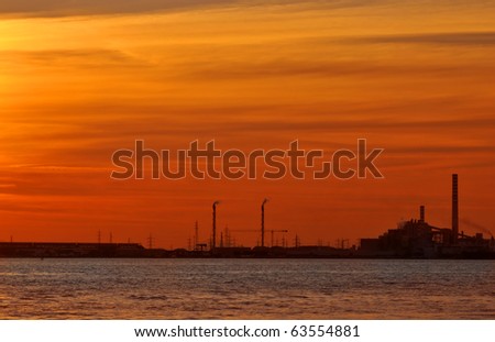 deep red sunset over an industrial skyline