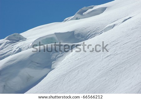 snow and ice on a glacier under clear blue skies
