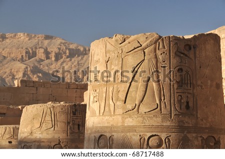 Broken column at the temple and palace of Rameses III with desert mountains in the background at Luxor in Egypt