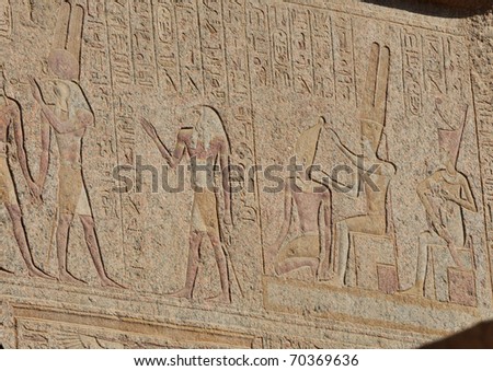 Detail from Karnak temple showing Ramses II and his queen wife nursing  their son with gods Horus and Amun in attendance