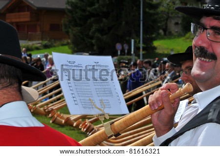 NENDAZ, SWITZERLAND - JULY 24: Happy player with his sheet music at the closing ceremony of the 10th International Festival of Alpine horns :  July 24, 2011 in Nendaz Switzerland