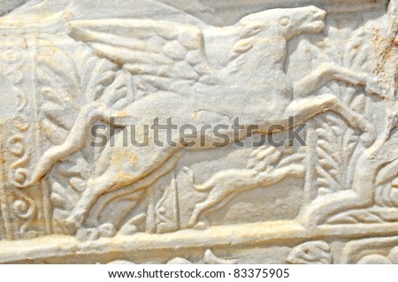 ancient roman sculpture of a pegasus, a mythical creature, part bird, part horse, being chased by a dog