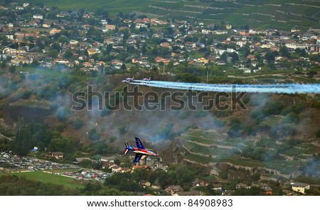 SION, SWITZERLAND - SEPTEMBER 17: Patrouille de France performing a cross over at the Breitling Air show.  September 17, 2011 in Sion, Switzerland
