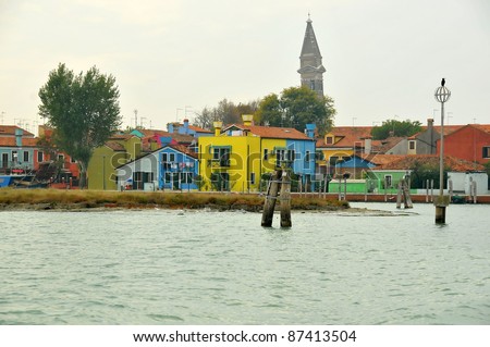 The venetian island of Burano famous for its multi-coloured houses.  Famous for its paintings and lace-making. With leaning clock tower