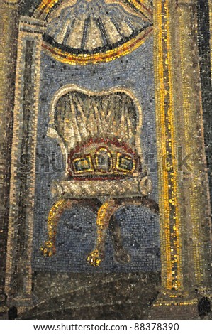 Ancient roman mosaic of an empty chair with animal claw feet grasping balls, and elaborate cushions