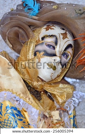 Gold and blue carnival masked lady in costume during the Venice Carnival