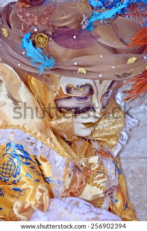 Sad carnival masked costume lady at the 2015 Venice Carnival dressed in glold and blue