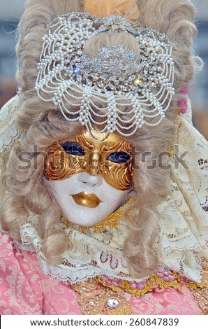 VENICE, ITALY - FEBRUARY 12: Carnival masked lady in pale pink with pearl tiara during the 2015 Venice Carnival:  February  12, 2015 in Venice, Italy