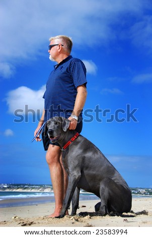Man\'s best friend - man with his great dane dog on the beach