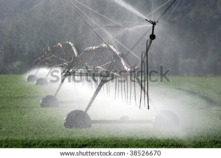 Modern irrigation pivot watering a farm field