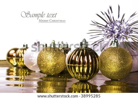 Gold and silver christmas decorations on a white background with space for text