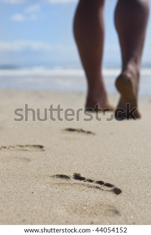 Person with strong calves walking on the beach