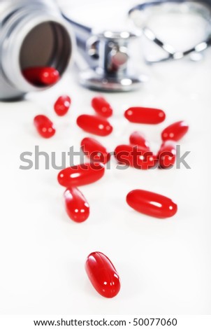 Pills spilled from a pill bottle on a white background