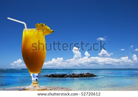 a Lovely cold fresh fruit cocktail with pineapple and straw on a tropical island beach