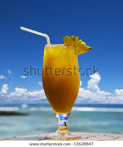 a Lovely cold fresh fruit cocktail with pineapple and straw on a tropical island beach